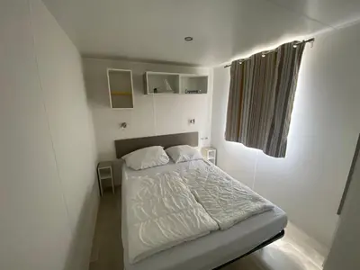Ein Bett oder Betten in einem Zimmer der Unterkunft Mobilheim Claudia mit Veranda am Kransburger See 555