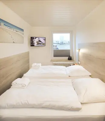 Ein Bett oder Betten in einem Zimmer der Unterkunft Rotesand - 117