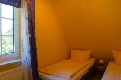 Ein Bett oder Betten in einem Zimmer der Unterkunft 4 Personen Fachwerkhaus in erster Reihe zum Deich mit Badewanne und Kamin