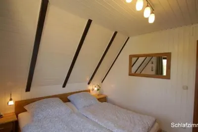 Ein Bett oder Betten in einem Zimmer der Unterkunft 6 Personen Ferienhaus mit 4 Schlafzimmern, Infrarotwaermekabine, mit Blick auf den Weltschiffahrtsweg in Otterndorf