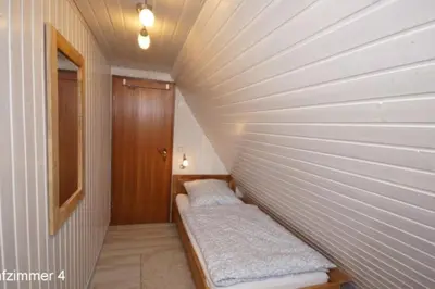 Ein Bett oder Betten in einem Zimmer der Unterkunft 6 Personen Ferienhaus mit 4 Schlafzimmern auf drei Etagen mit Blick auf den Weltschiffahrtsweg in Otterndorf