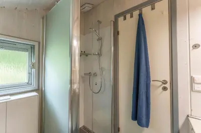 Ein Badezimmer in der Unterkunft 4 Personen Luxusferienhaus mit Sauna, Kaminofen, Klimaanlage, Kanu und Seeblick in Otterndorf