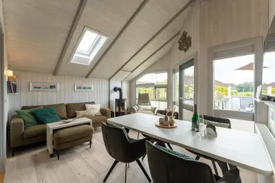 Ein Sitzbereich in der Unterkunft 4 Personen Luxusferienhaus mit Sauna, Kaminofen, Klimaanlage, Kanu und Seeblick in Otterndorf