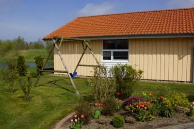 Ein Garten an der Unterkunft 4 Personen Ferienhaus mit privatem Bootsteg, direkter Seelage, Kanu und Sauna in Otterndorf
