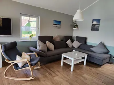Ein Sitzbereich in der Unterkunft 4 Personen Ferienhaus mit Kaminofen, Wintergarten und Kanu, mit einem wundervollen Blick auf den See in Otterndorf