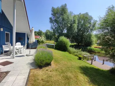 Ein Garten an der Unterkunft 6 Personen Ferienhaus mit privatem Bootsteg, direkter Seelage, Kanu, Sauna und Badewanne in Otterndorf