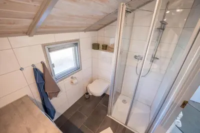 Ein Badezimmer in der Unterkunft Kinderfreundliches 5 Personen Wellnessferienhaus Treibholz mit zwei Duschen und Toiletten, Sauna, Whirlpool, Kaminofen, Wintergarten und Kanu in Otterndorf
