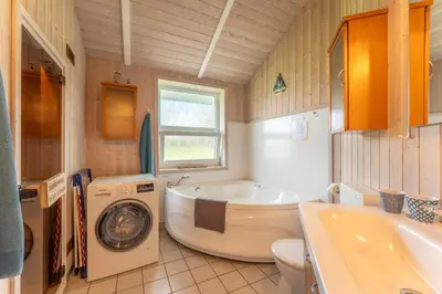 Ein Badezimmer in der Unterkunft 12 Personen Familienferienhaus mit Sauna, Whirlpool, zwei Duschen und Toiletten, Kaminofen und Kanu in 1. Reihe zum See mit wundervollem Seeblick in Otterndorf