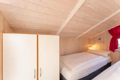 Ein Bett oder Betten in einem Zimmer der Unterkunft 12 Personen Familienferienhaus mit Sauna, Whirlpool, zwei Duschen und Toiletten, Kaminofen und Kanu in 1. Reihe zum See mit wundervollem Seeblick in Otterndorf
