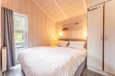 Ein Bett oder Betten in einem Zimmer der Unterkunft 4 Personen Ferienhaus mit Sauna, Kaminofen und einen wunderschцnen Garten mit Terrasse in Otterndorf
