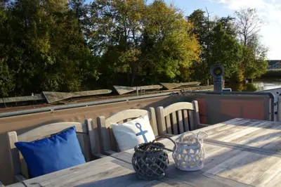 Ein Balkon oder eine Terrasse in der Unterkunft 8 Personen Hausboot mit Hot Tub, Sauna, Kaminofen, Klimaanlage, Lounge, Sonnendeck und Garten mit Buddelschiff direkt hinterm Deich in Otterndorf