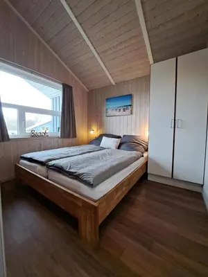 Ein Bett oder Betten in einem Zimmer der Unterkunft 6 Personen Ferienhaus mit Sauna, Whirlpool, Kaminofen und Kanu in 2. Rheie zum See in Otterndorf