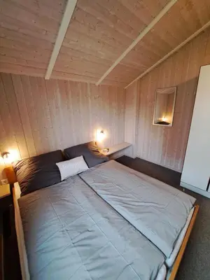 Ein Bett oder Betten in einem Zimmer der Unterkunft 6 Personen Ferienhaus mit Sauna, Whirlpool, Kaminofen und Kanu in 2. Rheie zum See in Otterndorf