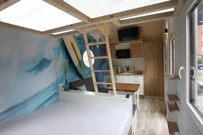 Ein Bett oder Betten in einem Zimmer der Unterkunft Tiny Wave Tiny House auf dem Campingplatz Strandgut