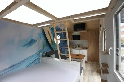 Ein Bett oder Betten in einem Zimmer der Unterkunft Tiny Wave Tiny House auf dem Campingplatz Strandgut