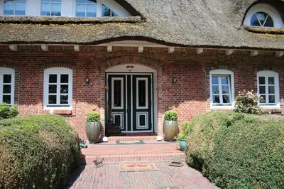 Eine Fassade oder ein Eingang zu Erlenhof Steinau Fachwerkhaus mit Reetdach